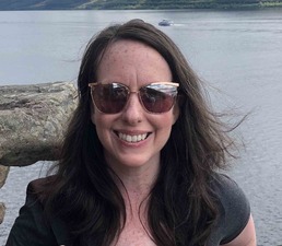 woman with brown hair and sunglasses smiling