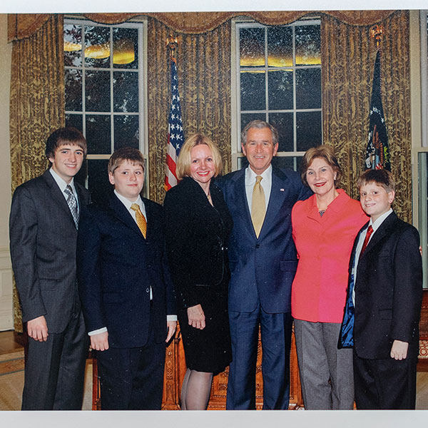 six people taking a picture dressed in suites at the White house 