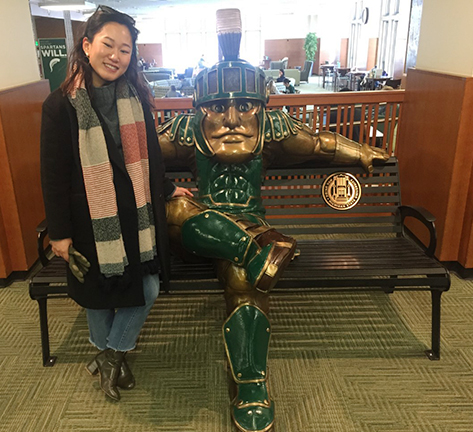 student with sparty statue