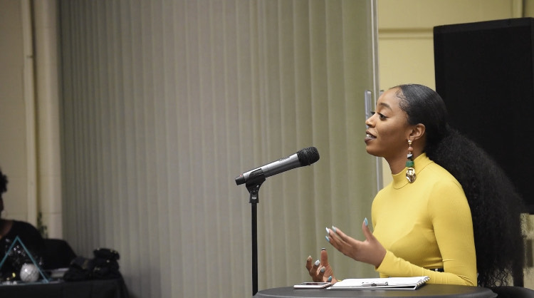 Ja'La Wourman speaking at a podium