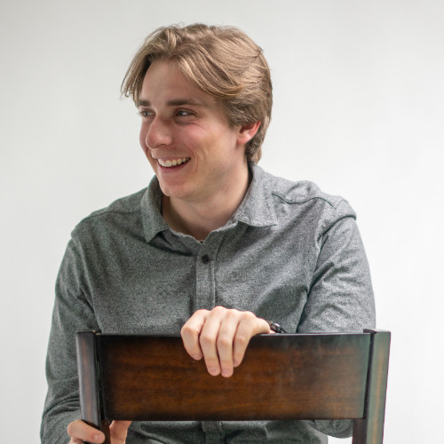 Image of a young person looking to the left and sitting backwards on a chair