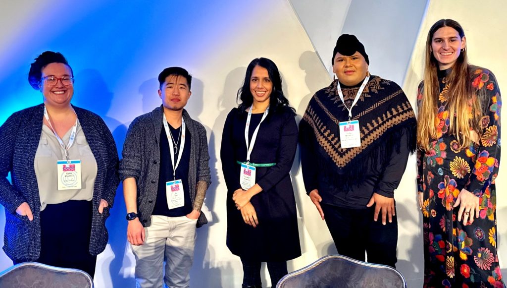 Five people all posing and smiling at the camera with each other.