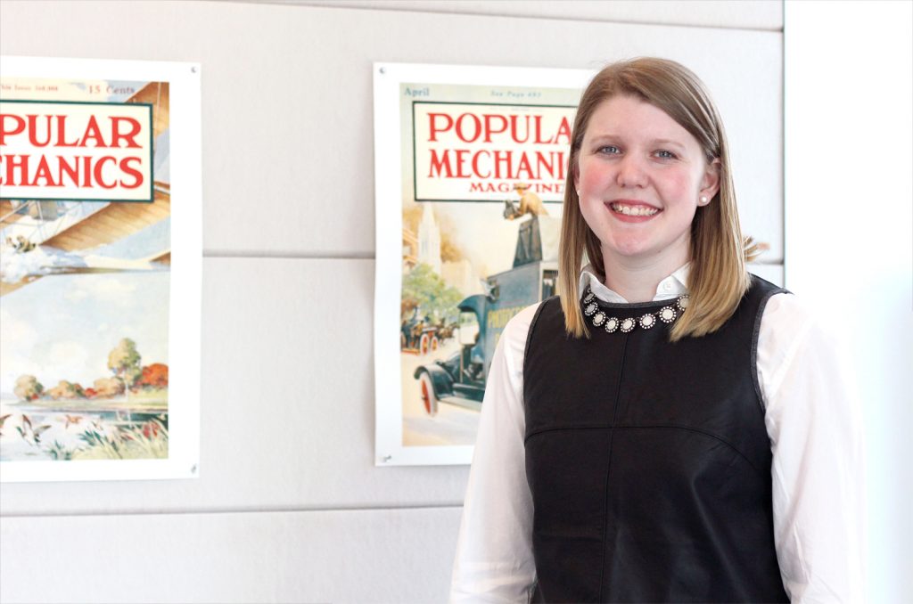Maude Campbell in front of a Popular Mechanics poster