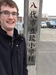 Josh Anderson next to a sign in Japanese