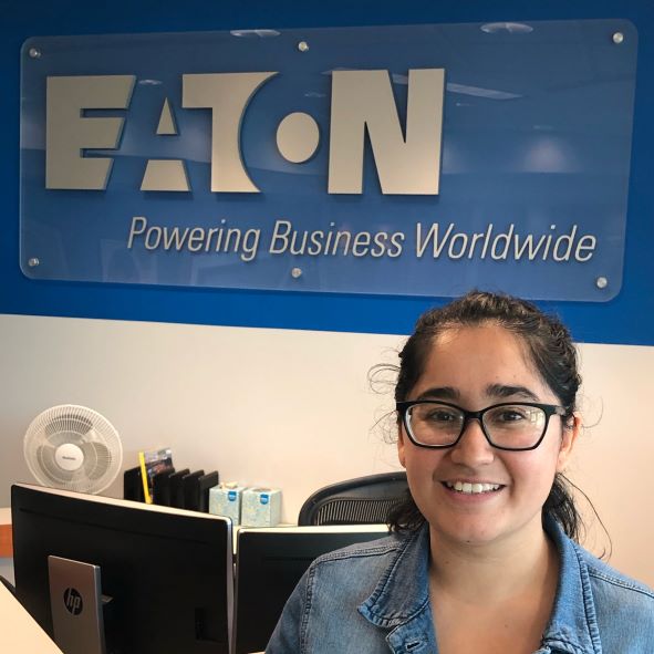 woman standing in front of a sign that says Eaton