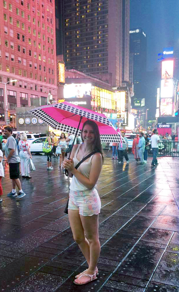 a girl in New York holding an umbrella