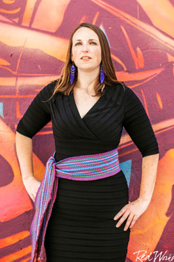 portrait of a woman in black dress against a colorful wall