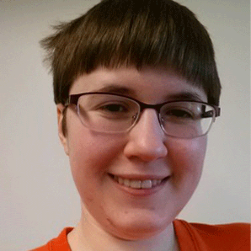 Headshot of a person with bowl-cut hair and glasses