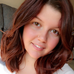 a smiling white woman with should-length reddish-brown hair