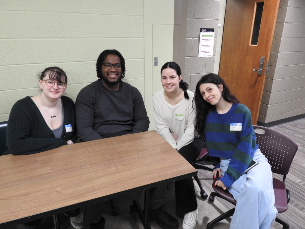 Four students sitting around a table at the First Year Writing Conference