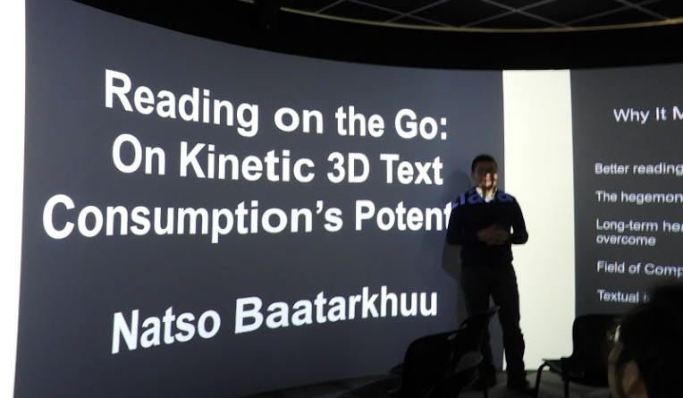 Narantsogt (Natso) Baatarkhuu stands in front of his title presentation slide. 
