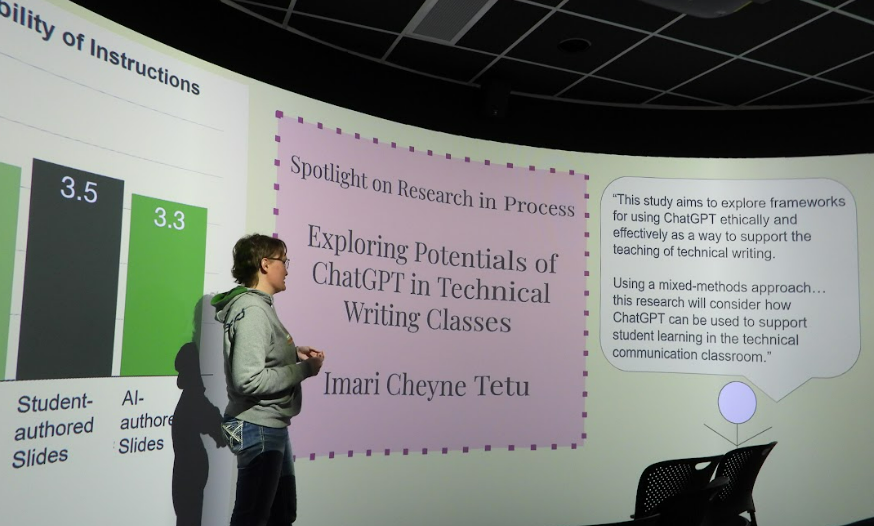 Imari Cheyne Tetu stands in front of her title presentation slide. 