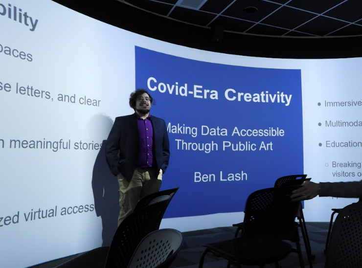 Ben Lash stands in front of his title presentation slide. 