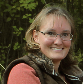 Imari Tetu; woman with blond hair, wearing glasses and smiling